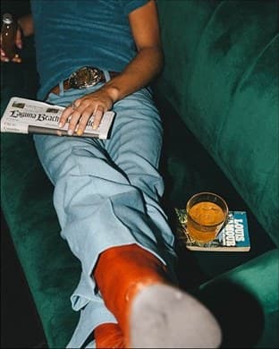 Vinyles et cocktail sur une banquette de velours